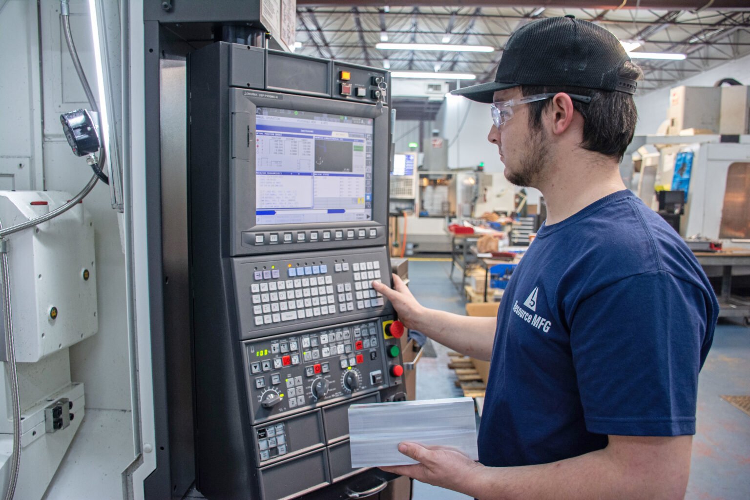 CNC operator inspecting machine controls
